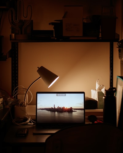 this shows a lamp and table with laptop signifying student life at the university of san francisco